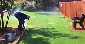 a Castle Rock sprinkler repair man adjusts a backyard sprinkler system